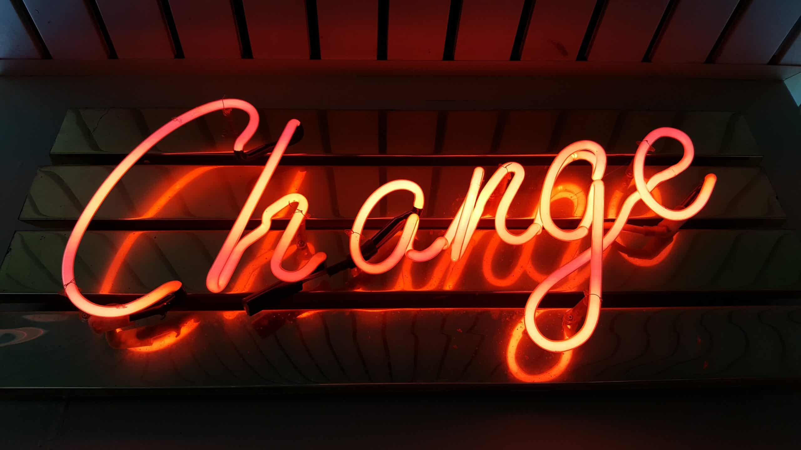 Warm orange neon sign reading 'change'. A health coach is essentially a change expert, who can help you to do things differently - and feel better.